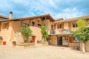an exterior view of a house with a courtyard at Les Aubépines en Beaujolais in Salles-Arbuissonnas