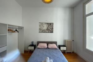 a bedroom with a bed with two pink pillows at Les Pieds dans le Bassin in Le Havre