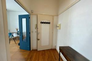 an empty room with a blue door and a table at Les Pieds dans le Bassin in Le Havre +7 photos