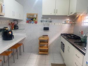 a white kitchen with white cabinets and a stove at Chalé em Praia Bela Paraíba in Pitimbu