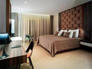 a hotel room with a large bed and a desk at Theatre Hotel in Olomouc