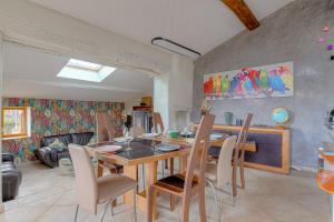 a dining room and living room with a table and chairs at Les Aubépines en Beaujolais in Salles-Arbuissonnas