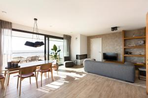 ein Wohnzimmer mit Tisch und Couch in der Unterkunft Droomsuites Egmond aan Zee 4 personen by Droomvilla in Egmond aan Zee