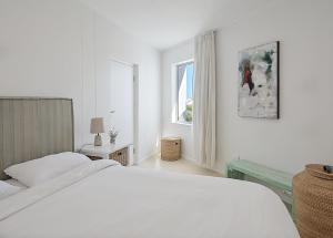 Beachfront, Sea Views, WiFi, Fireplace, 1-Min Walk في Cape Town: غرفة نوم بيضاء مع سرير ونافذة