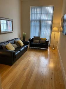 a living room with a black leather couch and chairs at The Waterfront Suite in Southport
