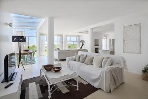 Beachfront, Sea Views, WiFi, Fireplace, 1-Min Walk في Cape Town: غرفة معيشة بيضاء مع أريكة بيضاء وطاولة
