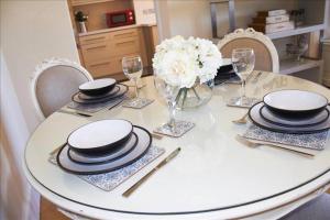 a white table with black and white plates and glasses at The Palm Suite in Southport