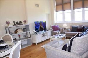 a living room with a couch and a tv at The Palm Suite in Southport +20 photos