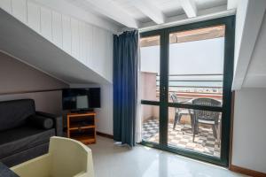 カヴァッリーノ・トレポルティにあるEurobeach Residenceのリビングルーム(ソファ、テーブル付)、バルコニーが備わります。