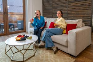 a man and a woman sitting on a couch at WILLA JAROSTA & SPA, AC -free parking in Zakopane