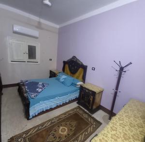 a bedroom with a bed with a blue comforter at Lotus 蓮 in Abu Simbel