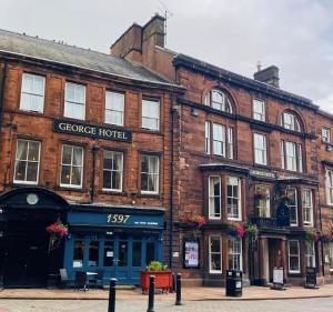 een bakstenen gebouw met een winkel op straat bij The George Hotel in Penrith