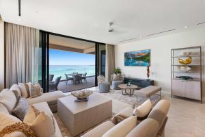 ナッソーにあるBeachfront 3 bedroom Luxury Residenceのリビングルーム(ソファ、眺めの良いテーブル付)