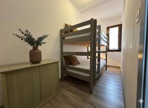 ボニファシオにある8 ARBOUSIERS VILLA 12の二段ベッドと植物が置かれた机のある部屋