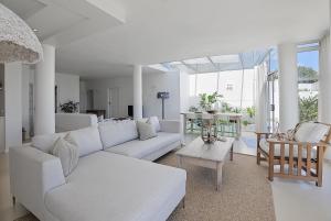Beachfront, Sea Views, WiFi, Fireplace, 1-Min Walk في Cape Town: غرفة معيشة مع أريكة بيضاء وطاولة