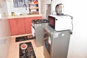 Il comprend une petite cuisine équipée d'une cuisinière et d'un réfrigérateur. dans l'établissement Comfy one bedroom Eldoret town, à Eldoret