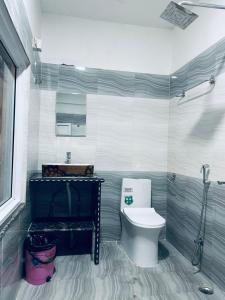 a bathroom with a white toilet and a shower at Kahun Danda Resort in Pokhara
