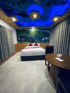 a bedroom with a bed with a painting on the wall at Kahun Danda Resort in Pokhara