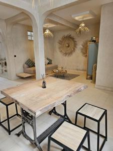 une grande table en bois dans une pièce avec un canapé dans l'établissement DAR NAYA - Ghazoua - Essaouira, à Al Ghar 19 autres photos