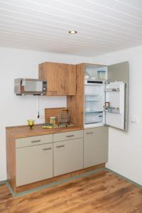 cocina con armarios blancos y nevera abierta en Ferienhaus im Pochwerksgrund in Suhl Goldlauter im Thüringer Wald, en Suhl