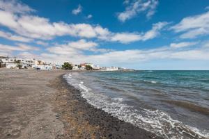 a beach with white buildings and the ocean at Home2Book Sunny Terrace Getaway Puerto Lajas in Puerto de las Lajas