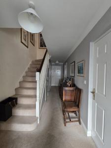 un couloir avec un escalier, une chaise et une lampe dans l'établissement Smiths Wharf, Wantage, à Wantage