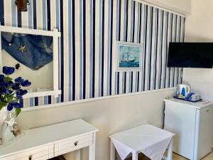 a room with a striped wall with a white refrigerator at Saint George Hotel in Rodakino