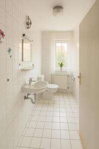 a white bathroom with a sink and a toilet at SUNNYHOME Monteurwohnungen und Apartments in Nittendorf in Nittendorf