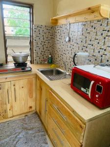 a kitchen with a red microwave on a counter at Studio cosy avec vaste terrasse in Cotonou