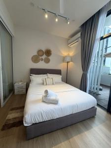コタキナバルにあるThe Shore KK - Sunset Sea View Balcony Suiteのタオルが敷かれたベッドのある寝室