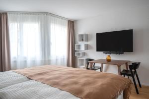 a bedroom with a bed and a tv and a table at PopUp - Stay3 self check in Apartments in Zürich