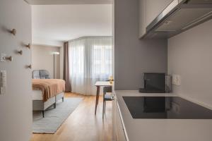 a room with a bed and a bedroom with a television at PopUp - Stay3 self check in Apartments in Zürich