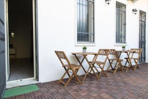 カターニアにあるRomano Roomsの木製テーブルと椅子が並ぶパティオ