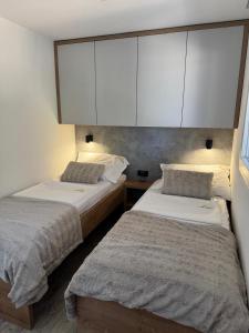 Dos camas en una habitación con armarios blancos. en Casa Mare Drage, en Drage