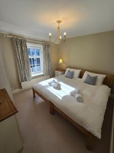a bedroom with a large bed with two towels on it at Grebe Cottage in Isle of Wight