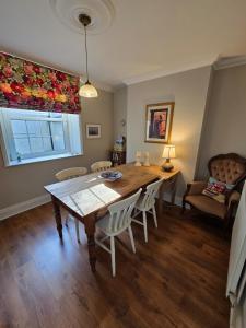 a dining room with a table and chairs and a window at Grebe Cottage in Isle of Wight