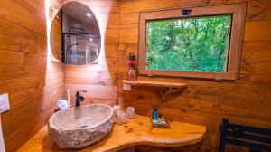 une salle de bain avec un lavabo et une fenêtre dans l'établissement Les cottages de Sarrant, à Sarrant