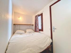 ein kleines Schlafzimmer mit einem Bett und einem Fenster in der Unterkunft Studio cozy à La Daille, accès direct pistes, balcon, ascenseur - FR-1-518-158 in Val dʼIsère