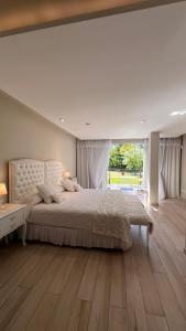 a bedroom with a large bed and a large window at La Posada Multiespacios in Dique Luján +36 photos