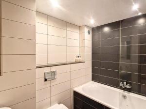 a white bathroom with a tub and a sink at Appartement cosy au Laisinant, accès direct pistes, idéal couples/familles - FR-1-518-124 in Val dʼIsère
