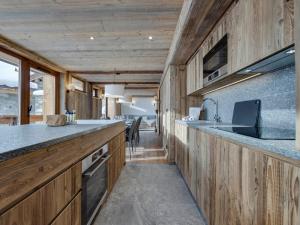 a kitchen with wooden cabinets and a counter top at Appartement 4 chambres à Tignes le Lac, proche des pistes, cheminée, parking couvert - FR-1-641-20 in Tignes +10 photos