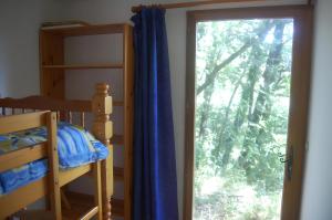 Un dormitorio con una litera y una ventana grande. en Gite Du Bas - À La Rouquette, en Saint-Privat