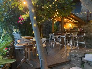 una terraza con mesas y sillas bajo un árbol con luces en Gite Du Haut - À La Rouquette, en Saint-Privat