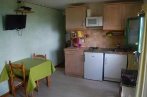 una cocina con mesa y una pequeña cocina con mesa y mesa en Gite Du Haut - À La Rouquette, en Saint-Privat