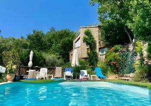 una piscina con sillas y sombrillas frente a una casa en Gite Du Haut - À La Rouquette, en Saint-Privat 14 fotos más