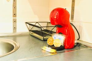 a red mixer sitting on a counter next to a sink at Gran Via Alaia Seasonal Living in Madrid