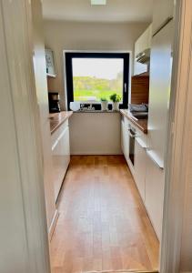 a small kitchen with a window and a wooden floor at Opa Meyer in Glücksburg +8 photos