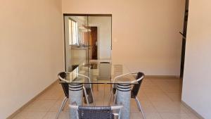 a glass table and chairs in a room at Casa Shanti Coliving Master in Dourados