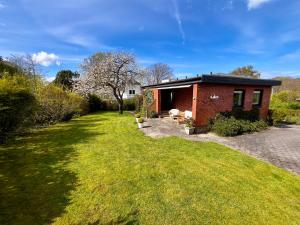 a small red brick house with a grass yard at Opa Meyer in Glücksburg