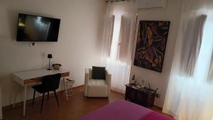 a room with a bed and a desk and a tv on the wall at Bilocale in Palazzo del XVI Secolo in Campobasso